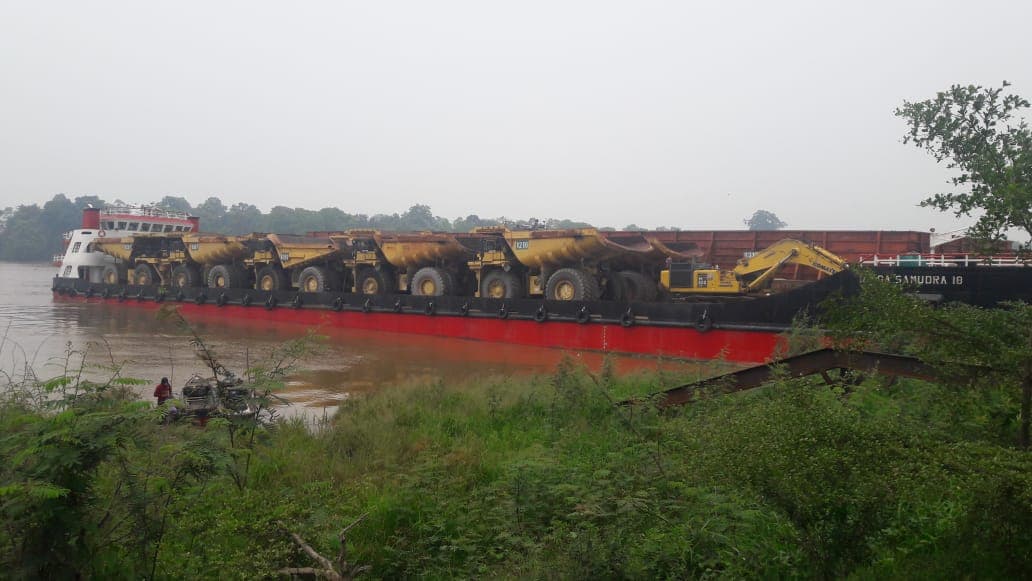 Deretan dump truck di atas tongkang pengangkut