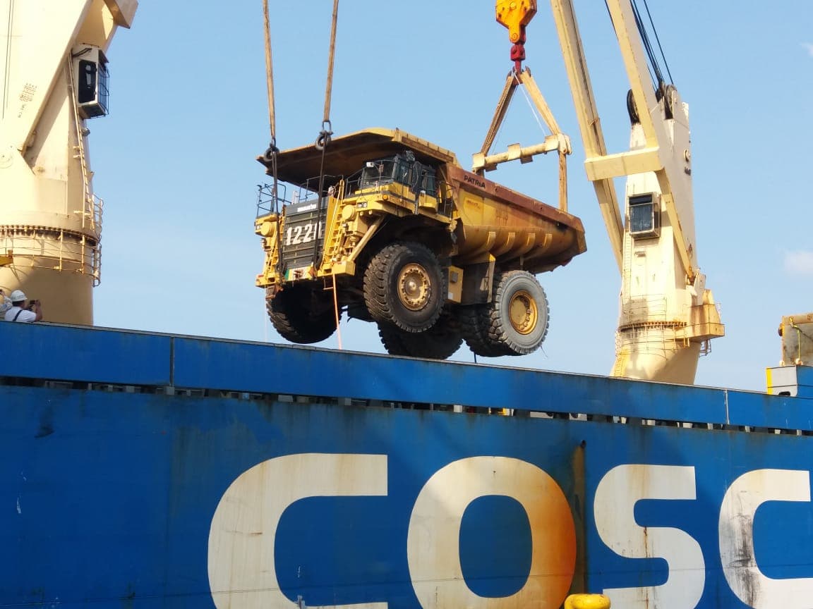 Dump truck diangkat crane saat proses muat ke kapal